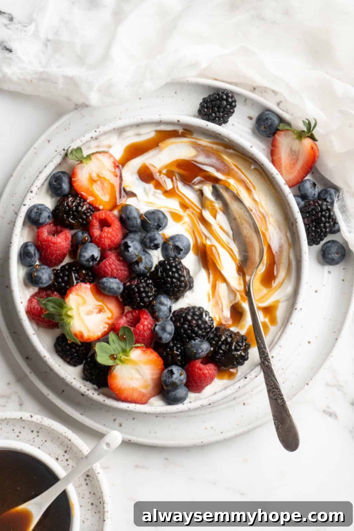 Date syrup gracefully swirled into a bowl of creamy yogurt topped with fresh, vibrant berries