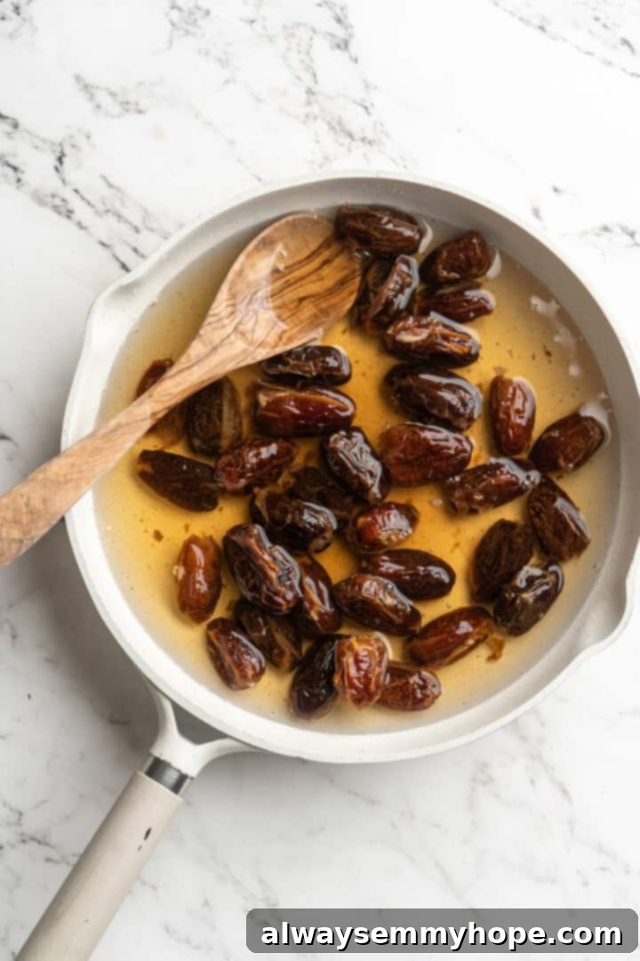 Overhead view of dates and water simmering gently in a saucepan, the mixture starting to break down
