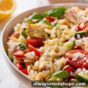 Closeup of orzo pasta salad with vegan feta and vegetables