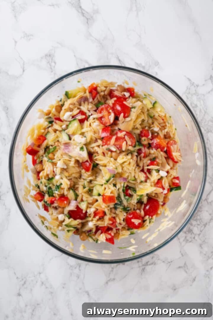 Overhead view of orzo pasta salad in glass bowl