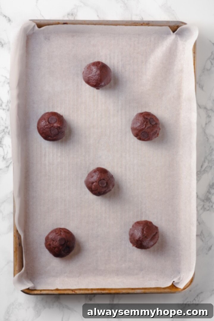 Overhead view of cookie dough rolled into balls and set on baking sheet