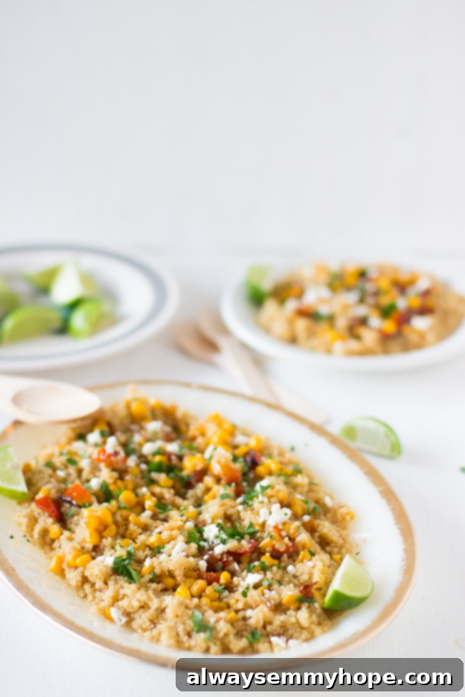 Quinoa and Corn Salad with Honey-Lime Dressing is hearty and delicious, made with roasted tomatoes and feta cheese. The perfect summer salad! Close-up shot of the fresh corn and quinoa in a long white dish, highlighting the colorful ingredients and the light dressing.