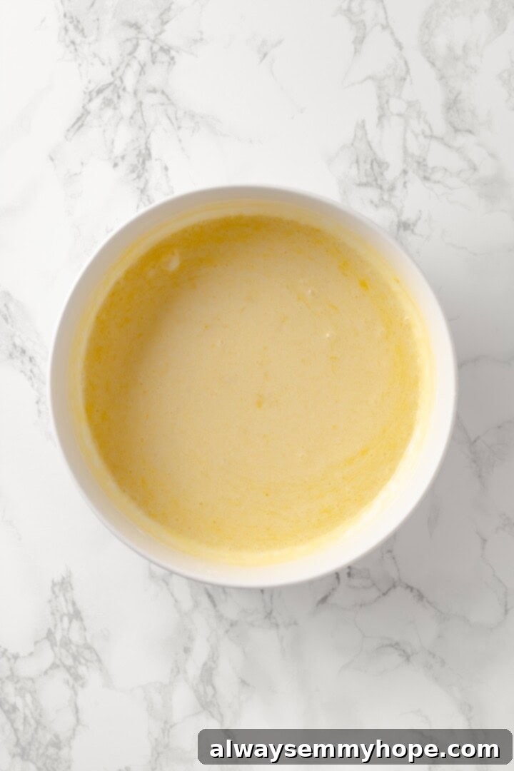 Mix the wet ingredients until well combined. Overhead view of wet ingredients (almond milk, melted vegan butter, applesauce, lemon juice, zest, vanilla) in a separate bowl, whisked until well combined.