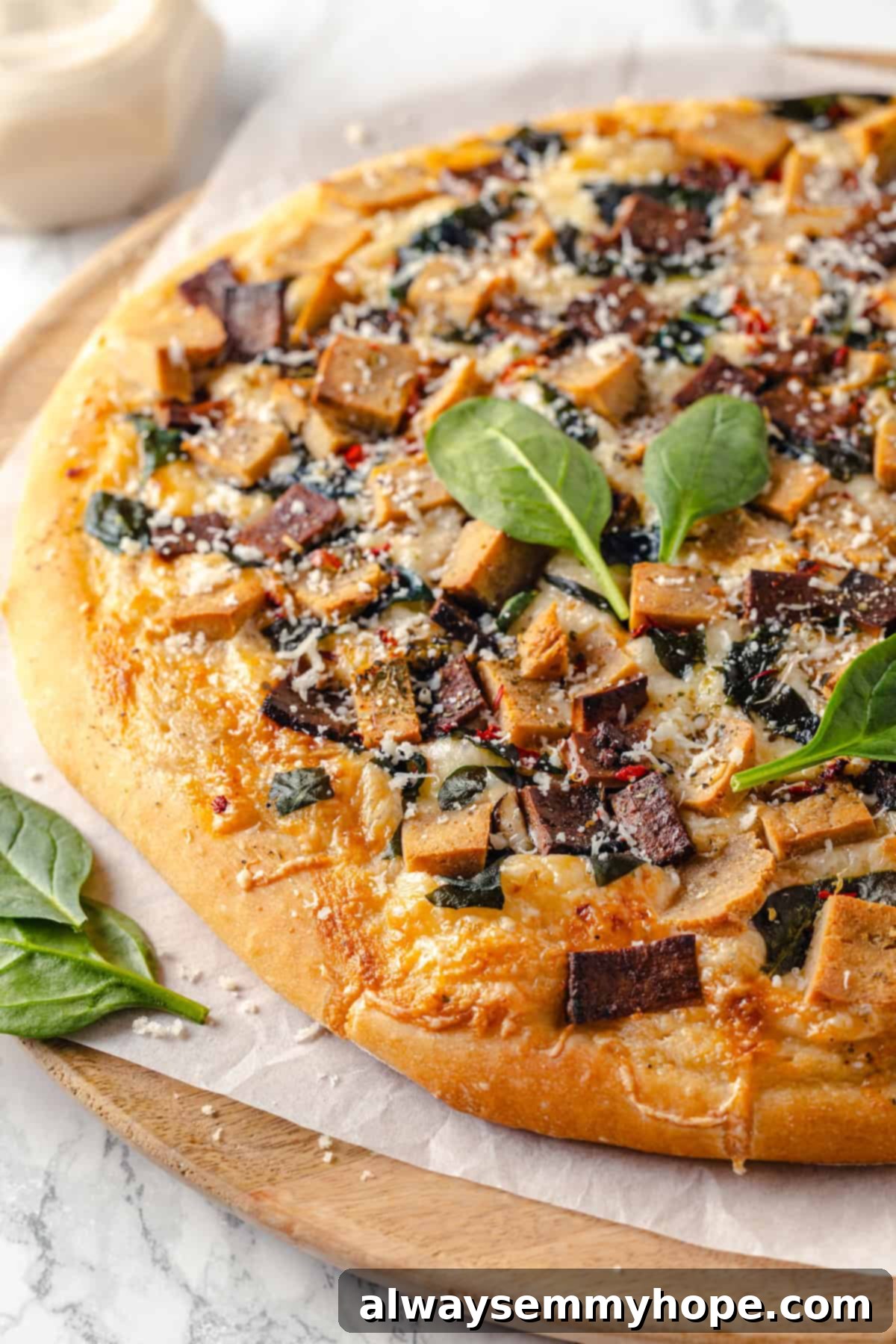 A creamy sauce makes this Alfredo sauce pizza taste indulgent, but it’s vegan! Plant-based chicken and bacon take this recipe over the top. Homemade Alfredo sauce pizza generously topped with vegan chicken and bacon, glistening and ready to eat.