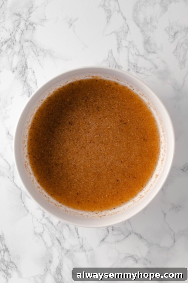 These homemade gluten-free bagels are chewy, delicious, and perfect for finishing with all your favourite toppings. So easy to make too! Overhead view of wet ingredients for gluten-free bagels in bowl