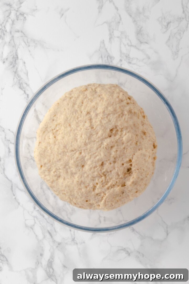 These homemade gluten-free bagels are chewy, delicious, and perfect for finishing with all your favourite toppings. So easy to make too! Overhead view of bagel dough in glass bowl after rising