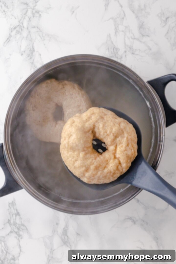 These homemade gluten-free bagels are chewy, delicious, and perfect for finishing with all your favourite toppings. So easy to make too! Dropping gluten-free bagel into pot of water