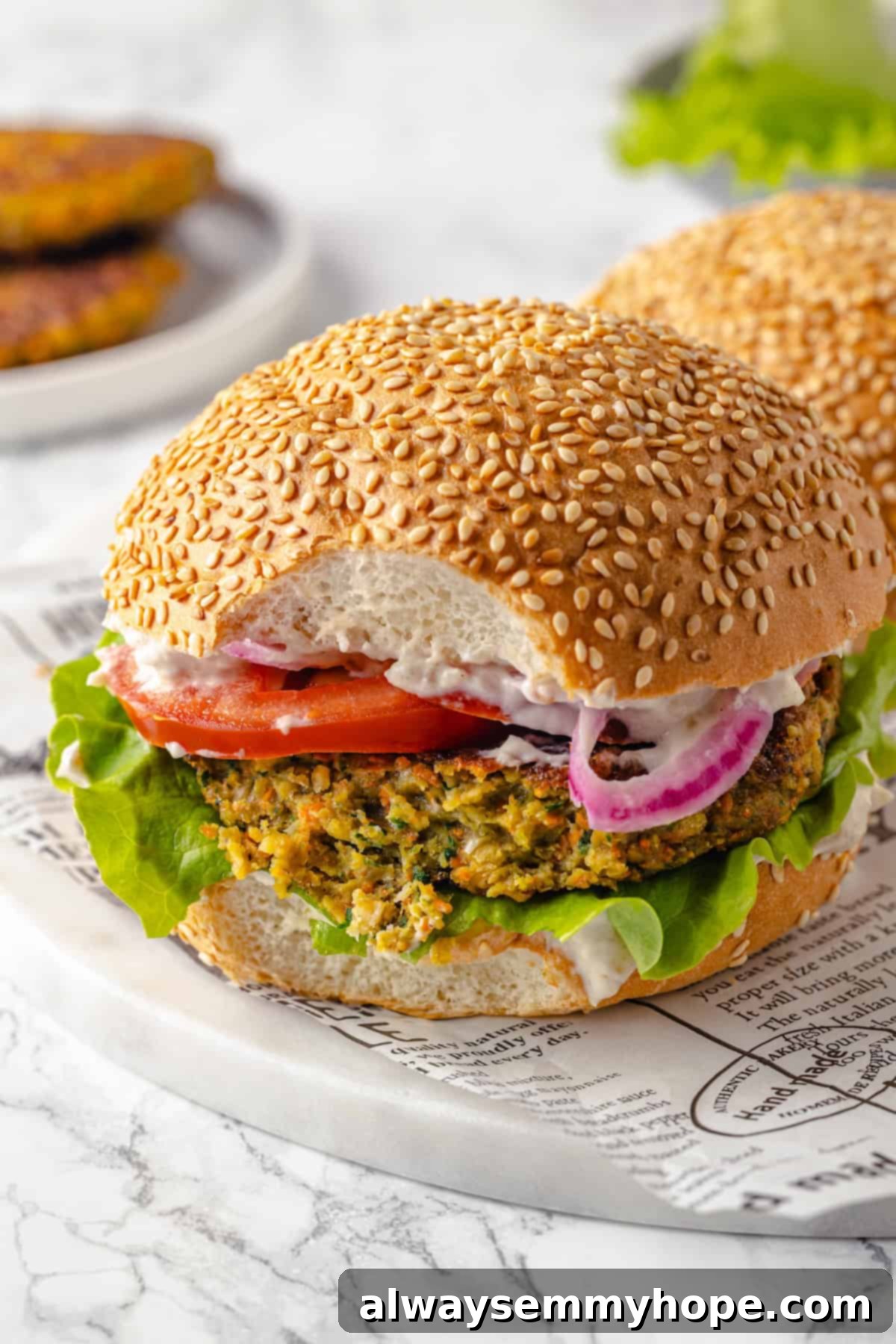 Close-up of a vegan falafel burger with a bite taken out, showing the flavorful and textured interior of the patty.