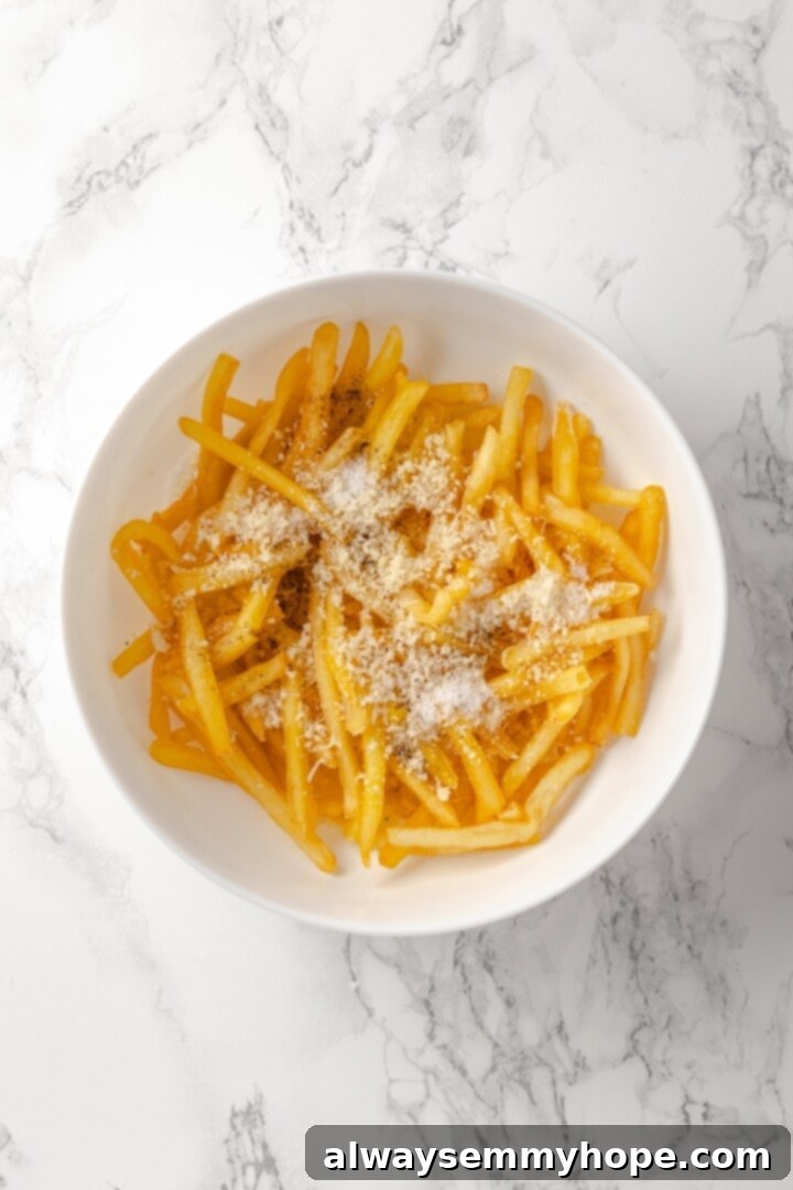 Vegan Parmesan added to bowl of truffle fries
