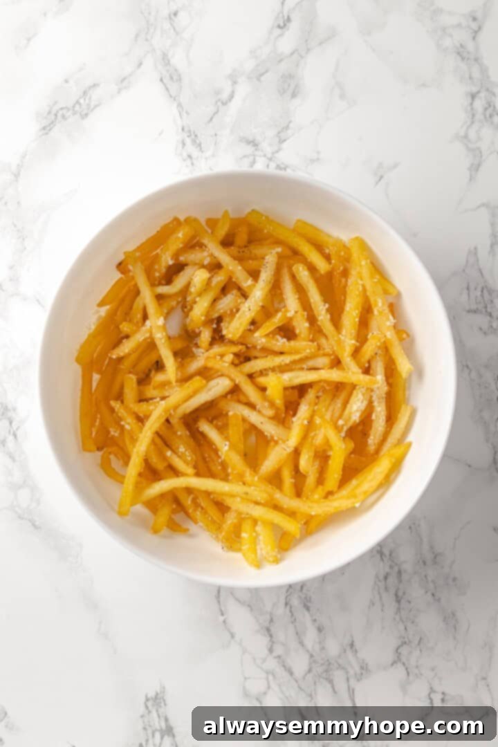 Overhead view of truffle fries in bowl with vegan Parmesan