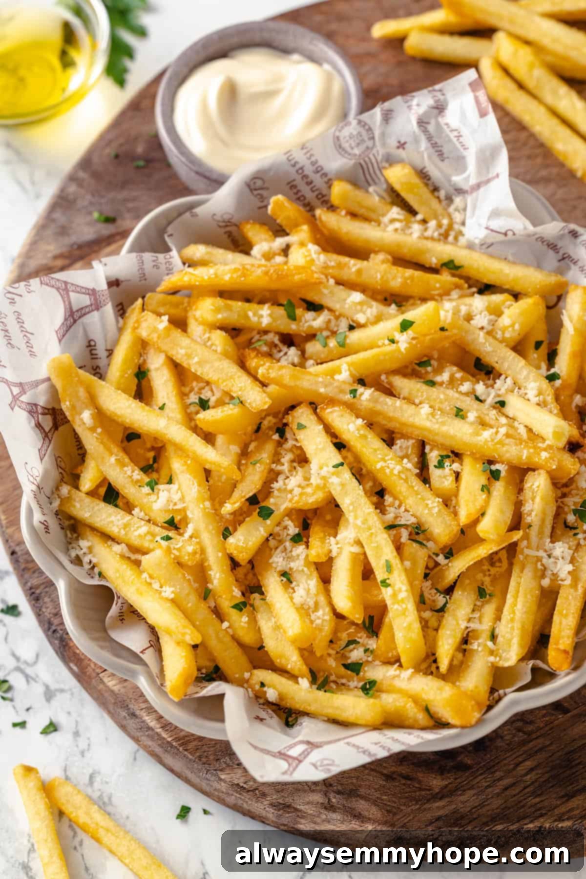 Overhead view of truffle fries in bowl set next to small bowl of aioli