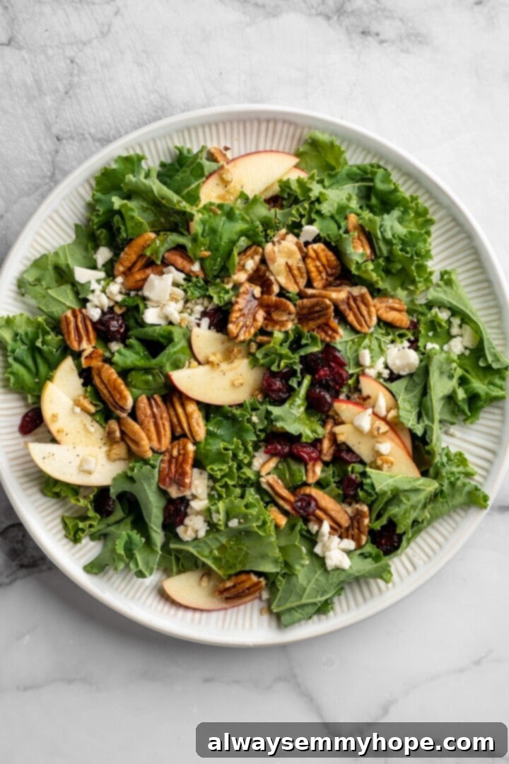 This vegan Apple, Pecan and Feta Salad is loaded with fall flavour! Sweet and crunchy, with a peppery maple vinaigrette to bring it together. Overhead view of the finished vegan apple, pecan, and feta salad in a bowl, perfectly tossed with dressing.