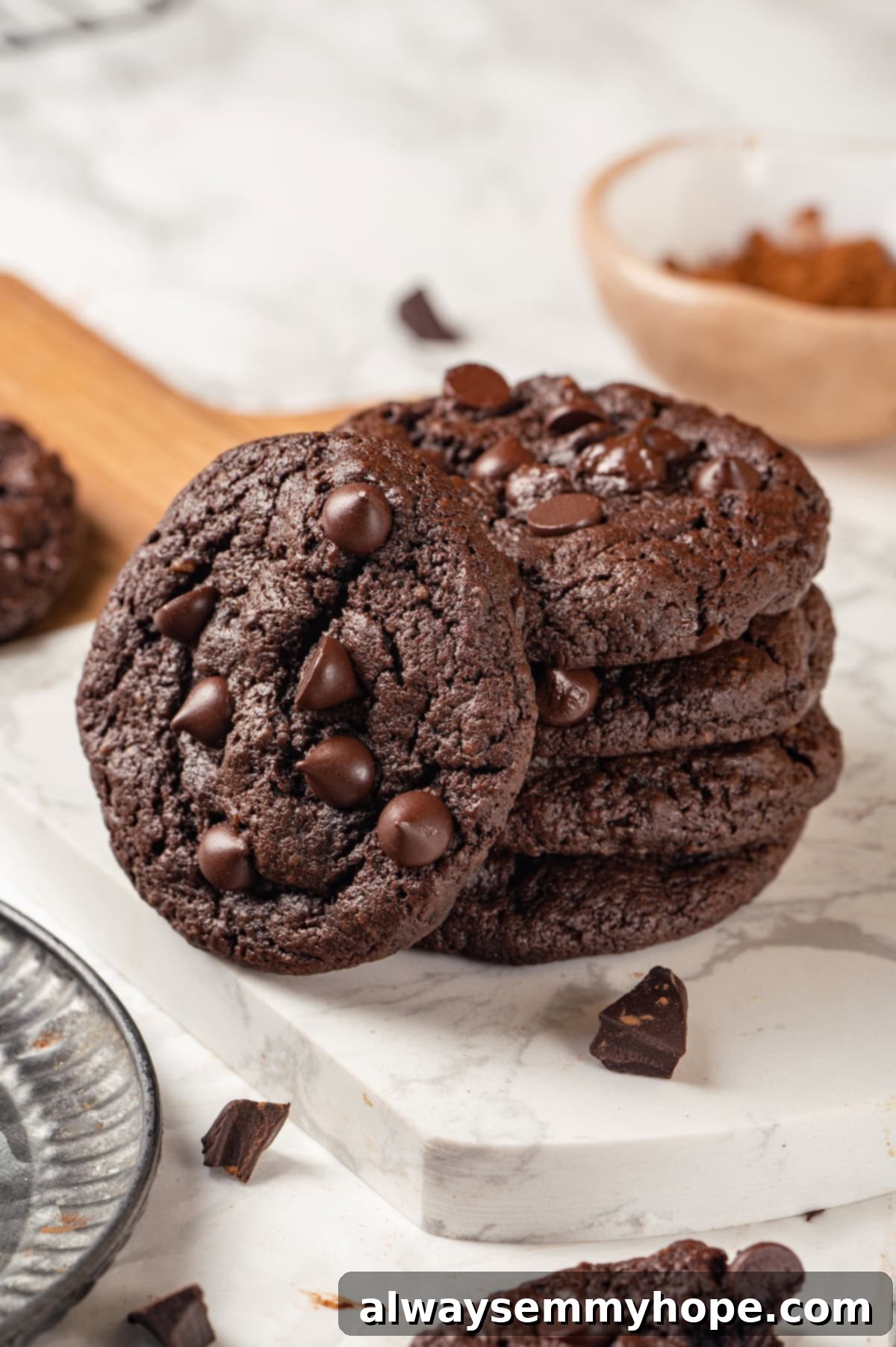 These double chocolate chunk cookies feature a rich, chewy chocolate cookie dough loaded with chocolate chips and dark chocolate chunks. Yum! Stack of 4 double chocolate chunk cookies with a fifth leaning against them