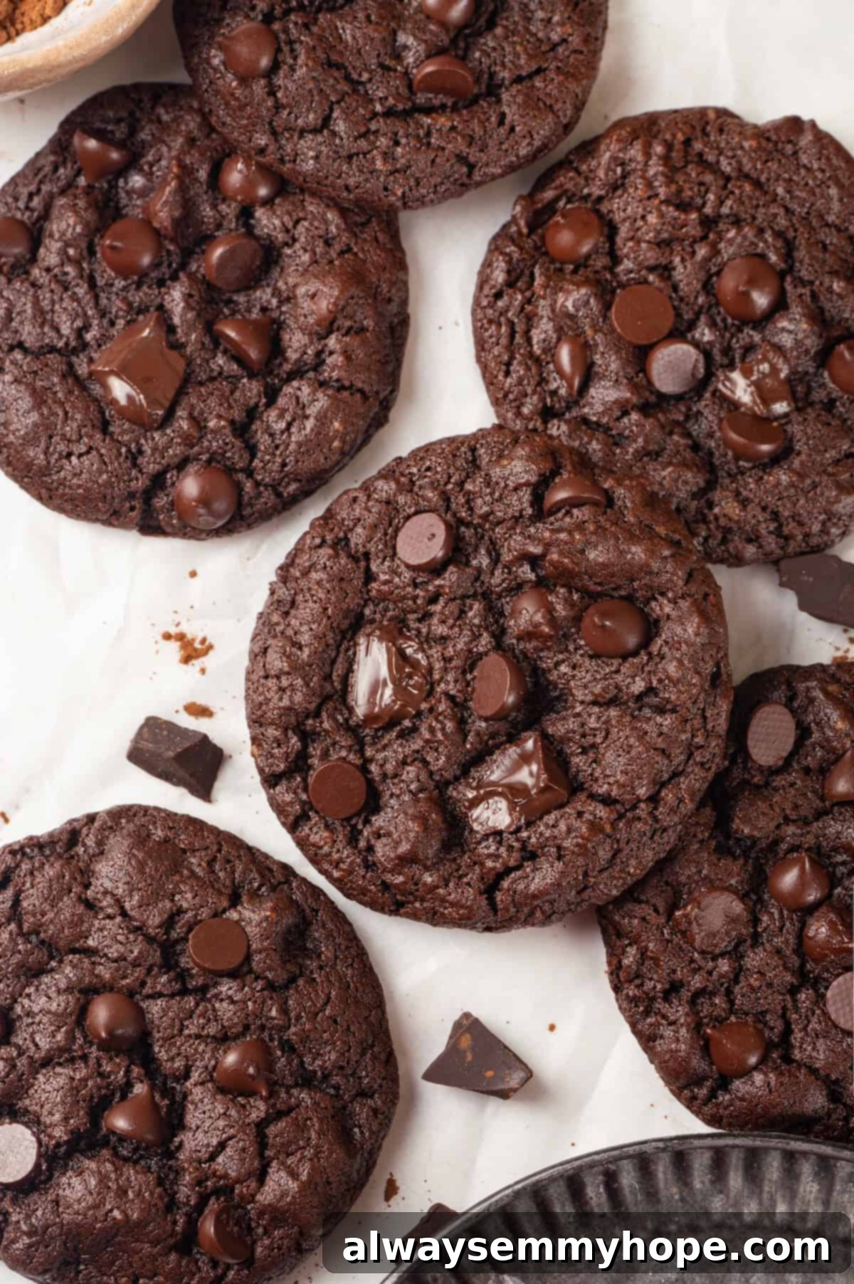 These double chocolate chunk cookies feature a rich, chewy chocolate cookie dough loaded with chocolate chips and dark chocolate chunks. Yum! Overhead view of double chocolate chunk cookies on parchment paper