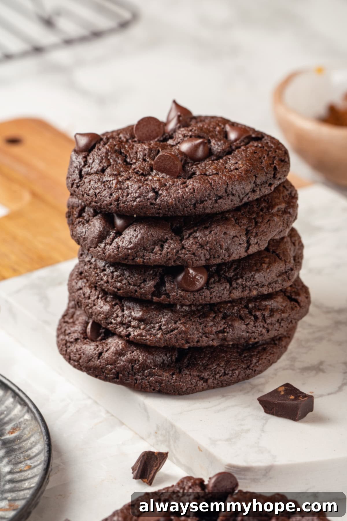 These double chocolate chunk cookies feature a rich, chewy chocolate cookie dough loaded with chocolate chips and dark chocolate chunks. Yum! Stack of 5 double chocolate chunk cookies on marble board
