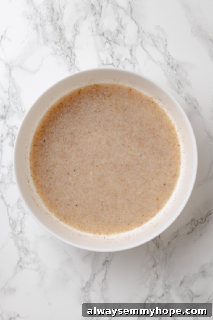 This homemade gluten-free English muffin recipe is tender, golden, and perfect for adding your favourite jam or spread. They're vegan too! Large bowl with psyllium husk and water mixture, showing the gelled consistency.