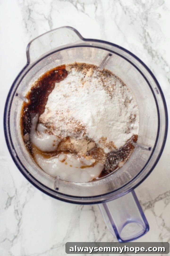 Overhead view of all ingredients for protein waffles in a blender, forming a smooth batter, ready for cooking