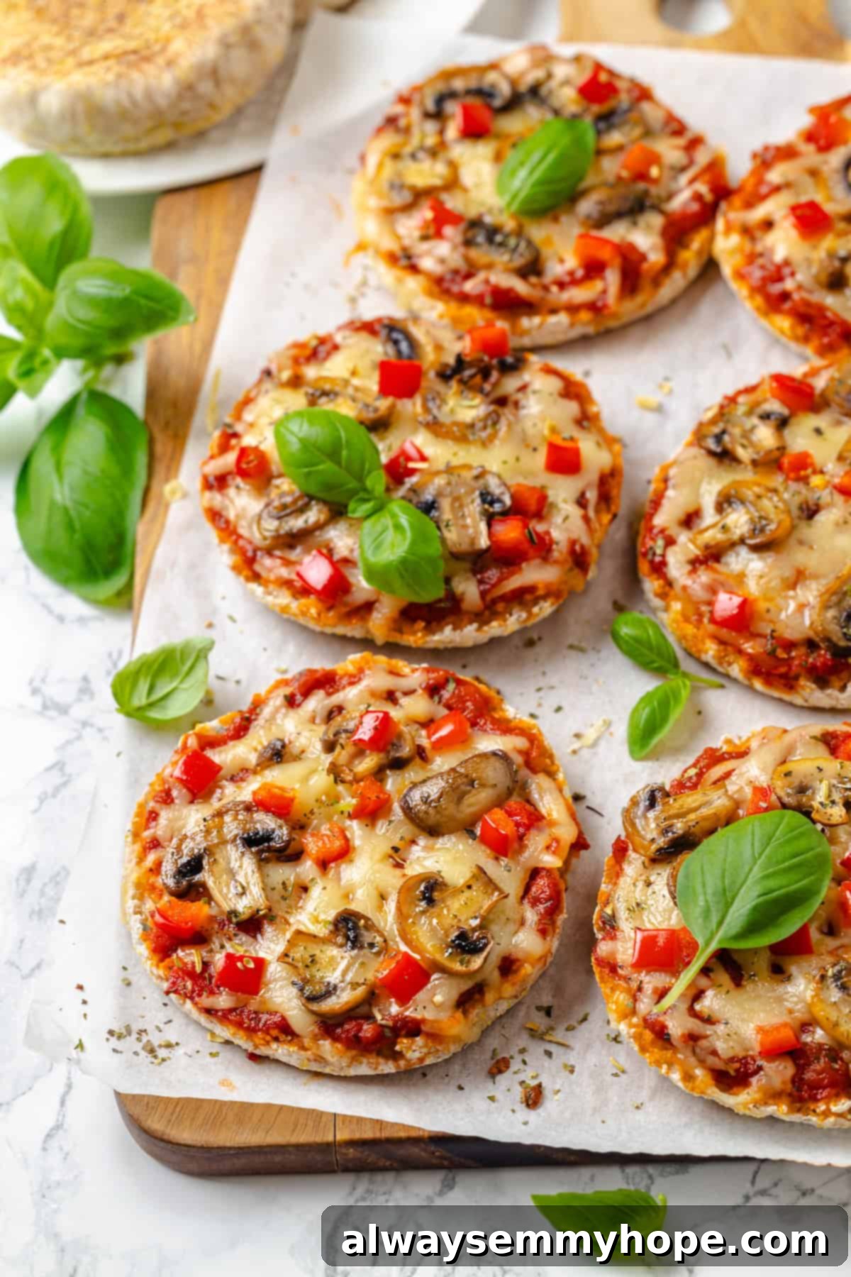 English muffin pizzas topped with red bell pepper and mushrooms