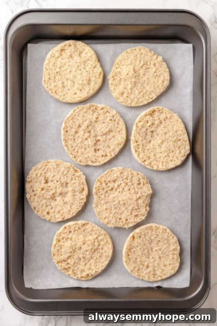 Overhead view of English muffin halves on sheet pan