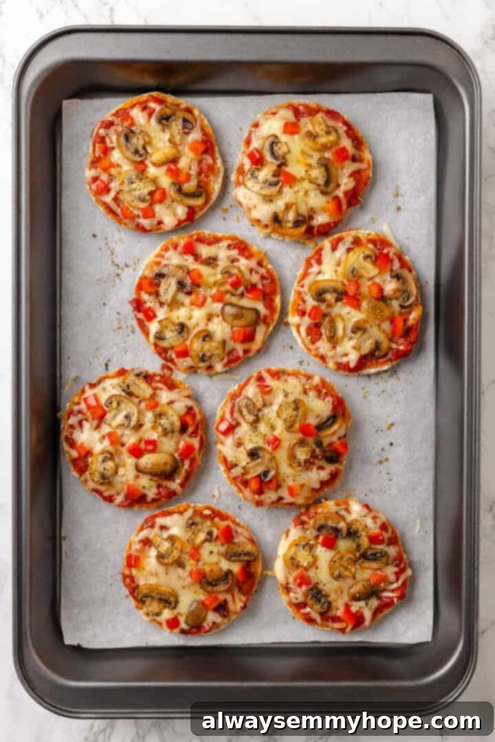 Overhead view of English muffin pizzas on baking sheet