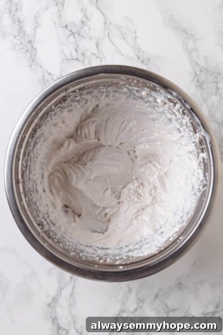 With an Oreo crust, decadent vegan mousse filling, and coconut whipped cream, this chocolate mousse pie recipe is absolutely irresistible! Overhead view of fluffy whipped coconut cream in a mixing bowl