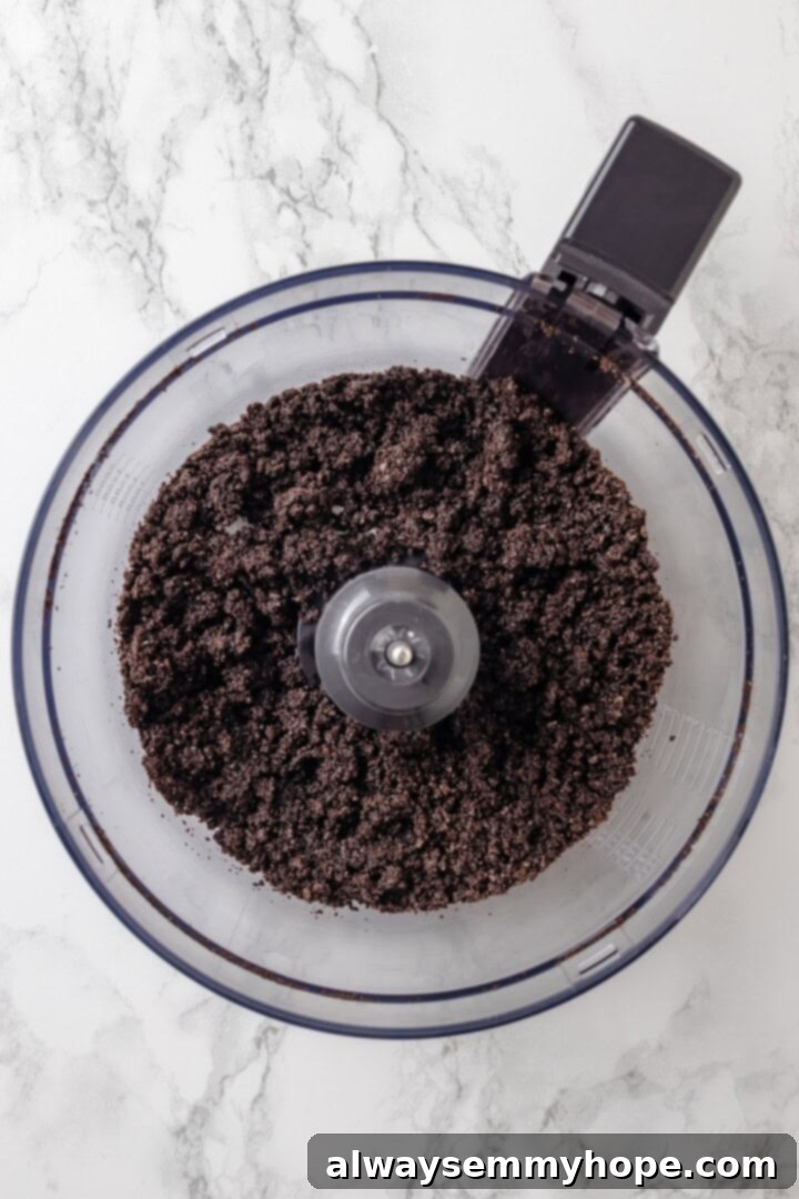 With an Oreo crust, decadent vegan mousse filling, and coconut whipped cream, this chocolate mousse pie recipe is absolutely irresistible! Overhead view of Oreo crumbs in food processor bowl, ready to be mixed