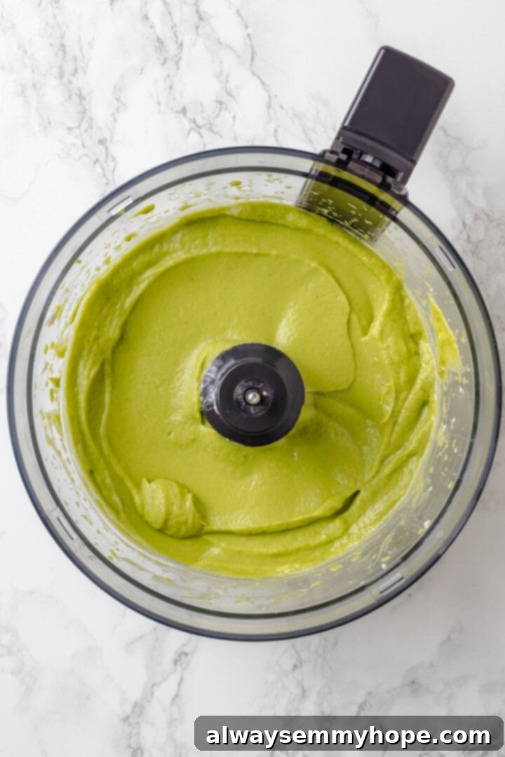 With an Oreo crust, decadent vegan mousse filling, and coconut whipped cream, this chocolate mousse pie recipe is absolutely irresistible! Overhead view of pureed avocado mixture in a food processor bowl, ready for chocolate