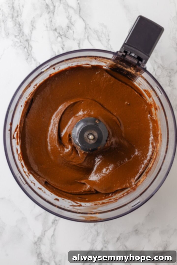 With an Oreo crust, decadent vegan mousse filling, and coconut whipped cream, this chocolate mousse pie recipe is absolutely irresistible! Overhead view of finished vegan chocolate mousse filling in a food processor