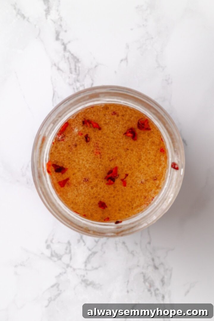 Overhead view of a small bowl containing the freshly whisked ginger dressing, ready to be added to the salad