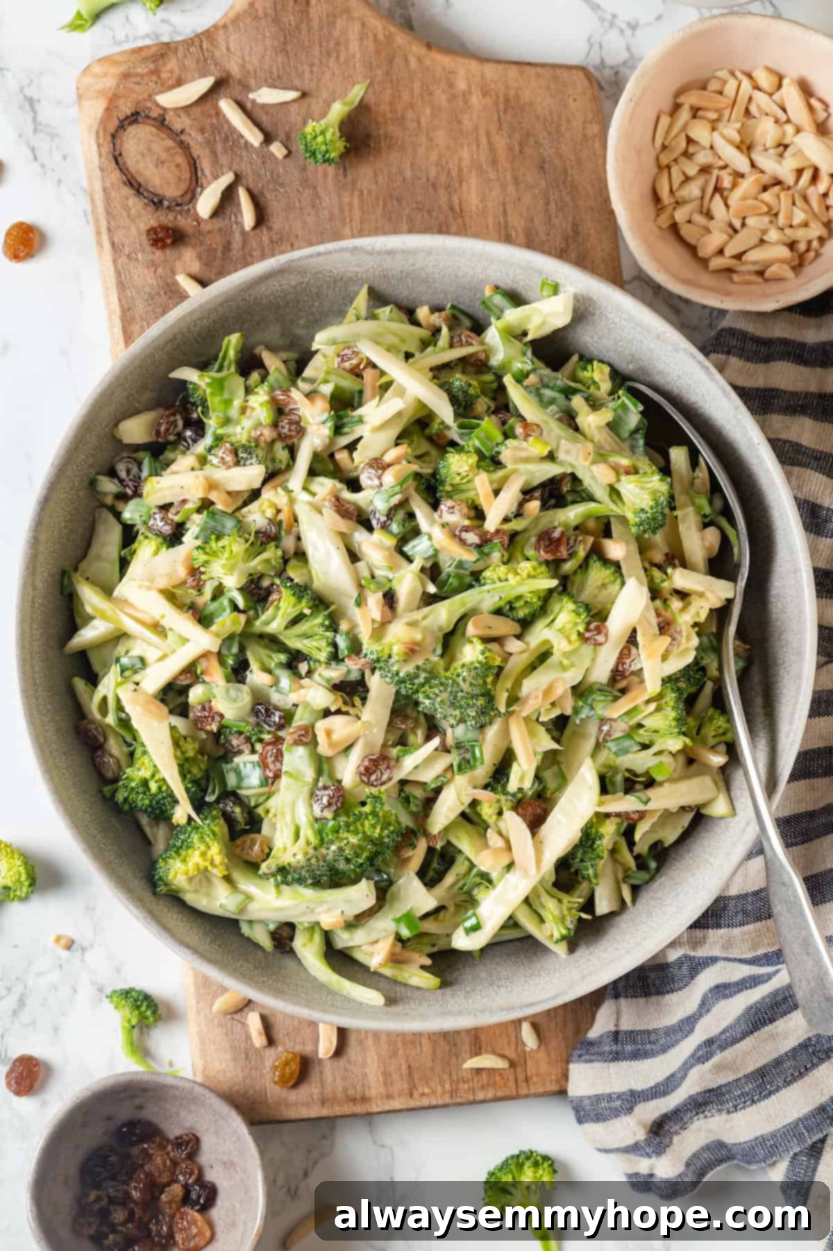 This easy broccoli slaw recipe is crisp and crunchy, sweet and savory, with a creamy dressing so good, you’ll want to eat it with a spoon! Overhead view of broccoli slaw in bowl with spoon