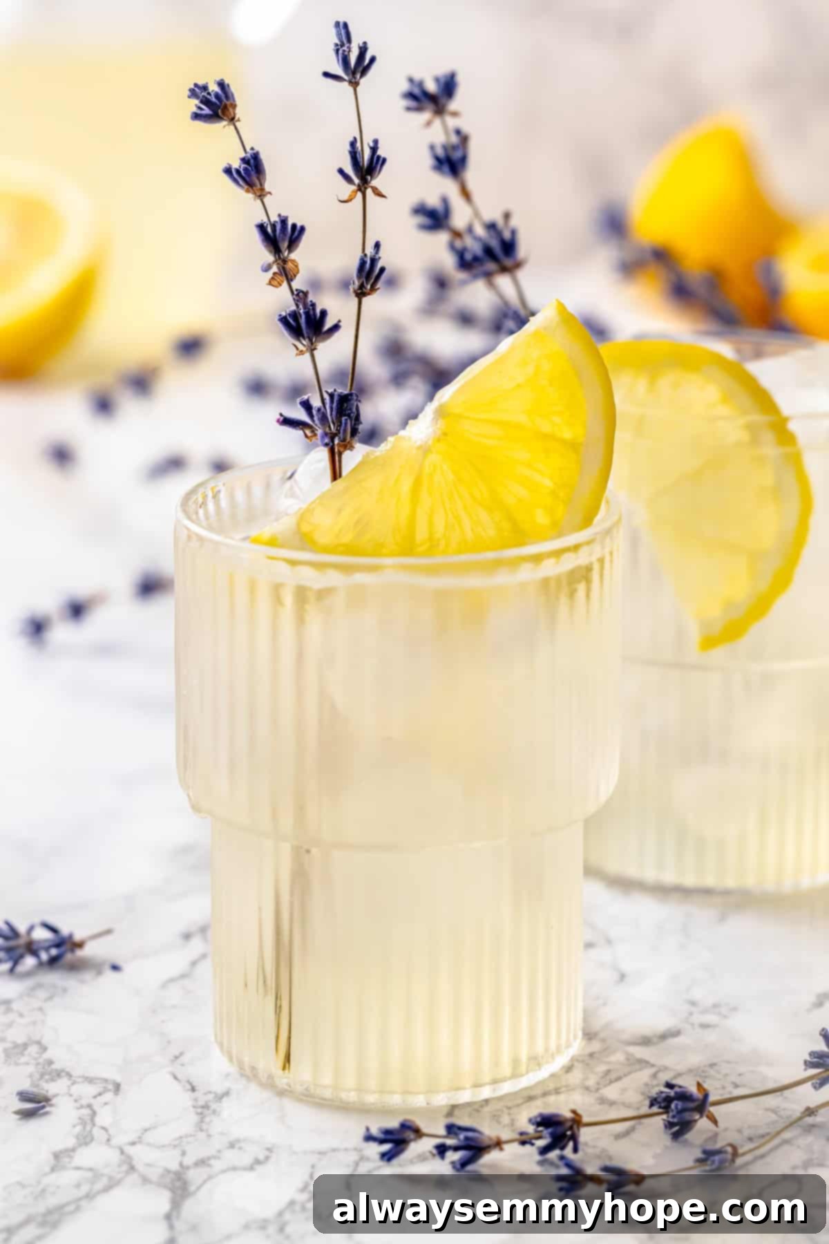 Two glasses of lavender lemonade with lemon slices and lavender sprigs, a perfect summer drink