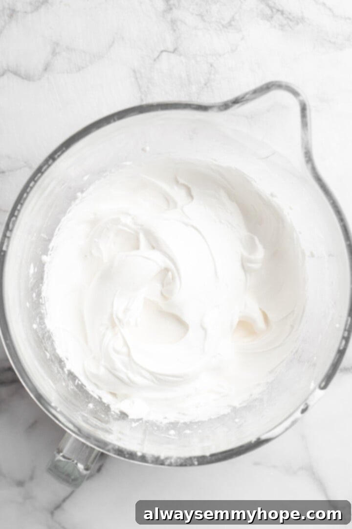 Overhead view of aquafaba mixture in glass mixing bowl before adding butter and vanilla