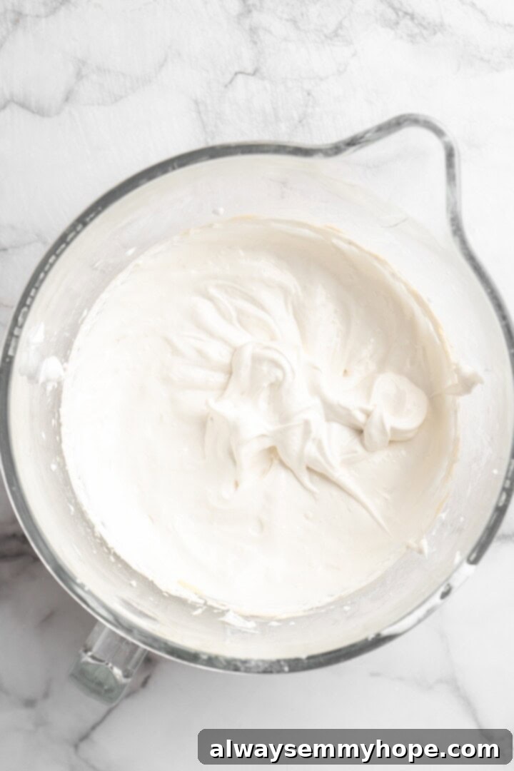 Overhead view of aquafaba mixture in glass mixing bowl
