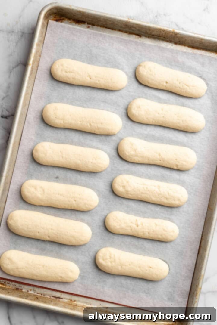 Overhead view of vegan ladyfingers on parchment-lined baking sheet