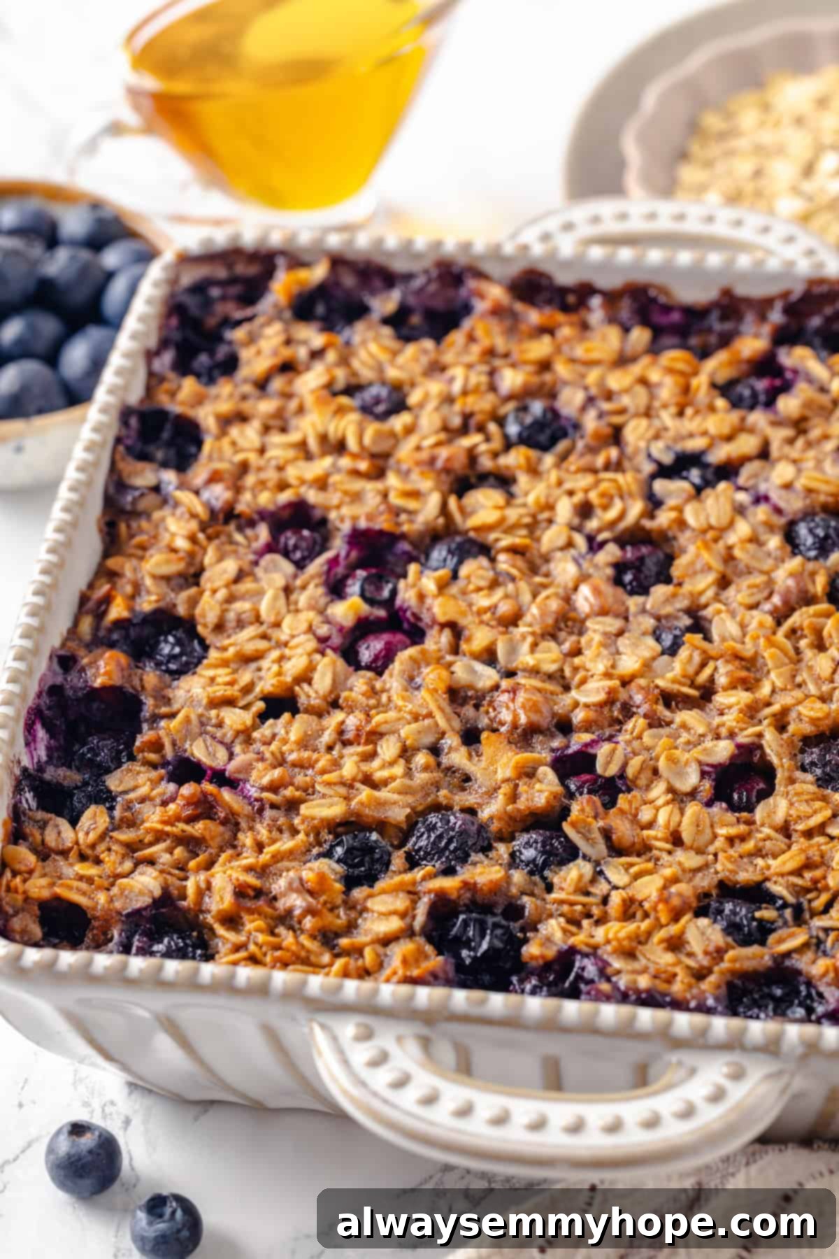 This baked oatmeal recipe is an easy meal prep breakfast! It's hearty and wholesome, with juicy berries and crunchy walnuts in every bite. Baked oatmeal with blueberries in baking dish, ready to be served