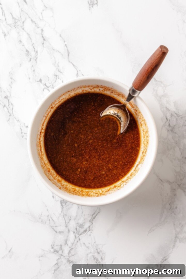 Rice paper is the secret for ultra crispy vegan bacon! This recipe is smoky, sweet, and savoury, and it's incredibly easy to make too. Marinade mixture for vegan bacon in bowl with spoon