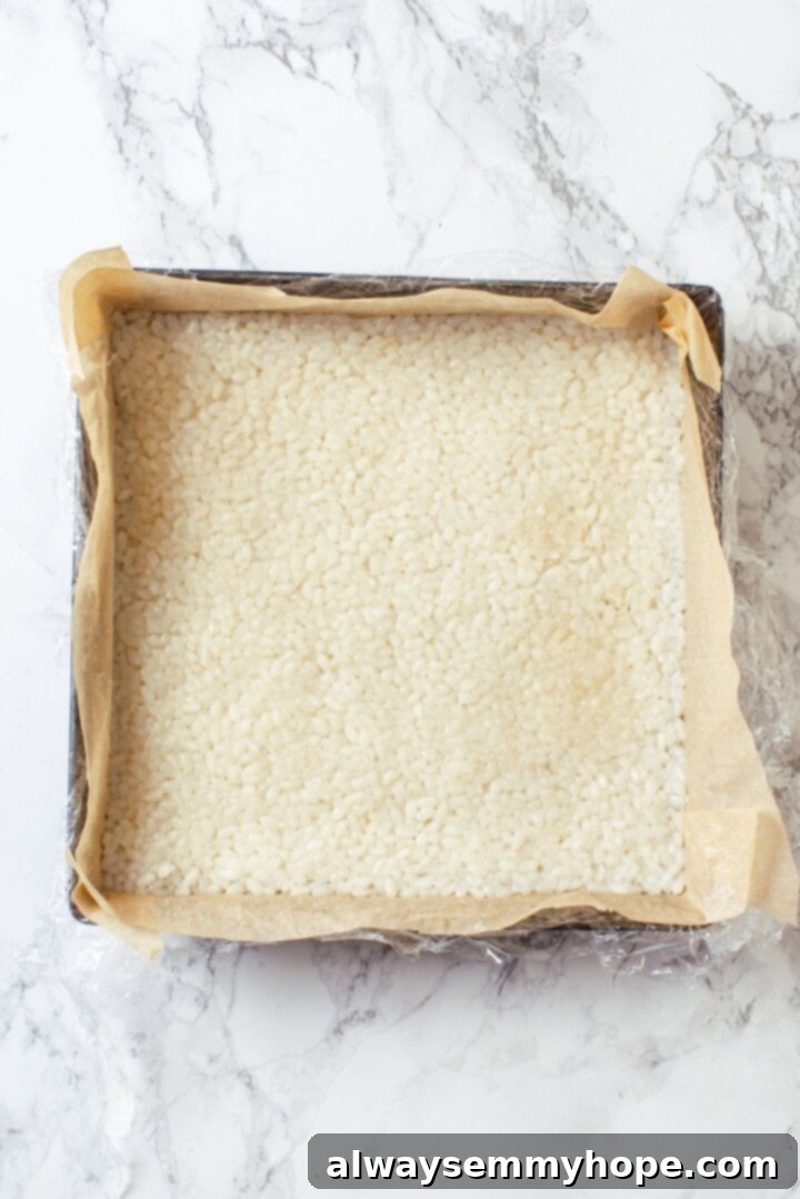 Sushi rice pressed into square baking dish