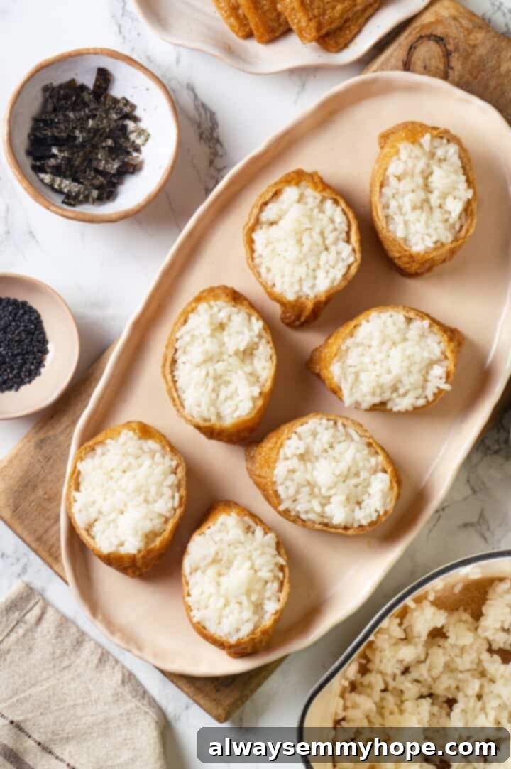 This inari sushi recipe tucks tangy sushi rice into tofu pockets with toppings like avocado, spicy carrots, and tofu scramble. Easy and fun! Overhead view of inari sushi on platter before adding toppings