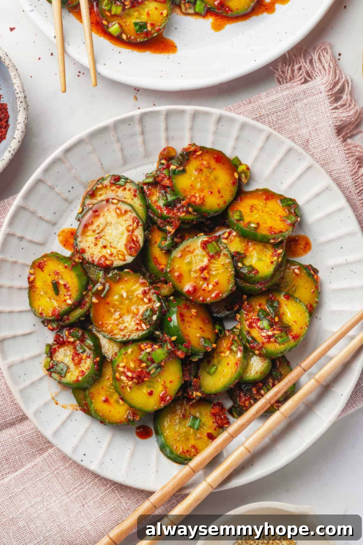 Crisp, refreshing, and full of bold flavour, this spicy Korean cucumber salad recipe is an easy side dish you’ll make all summer long! Overhead view of Korean cucumber salad on a plate with chopsticks, ready to eat