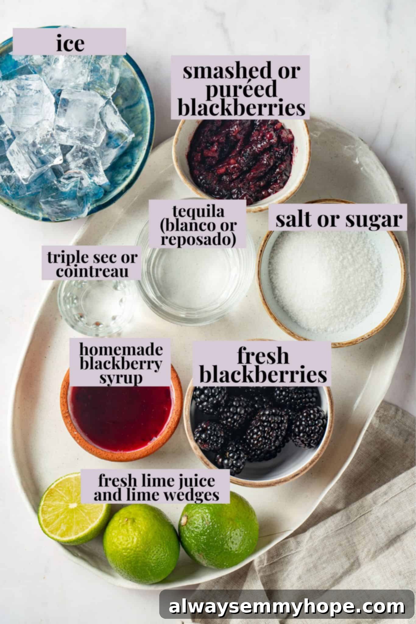 This summery blackberry margarita recipe is refreshing, delicious, and perfect for adding to your Taco Tuesday menu. It's always a hit! Overhead view of a cocktail shaker, tequila, orange liqueur, lime juice, and fresh blackberries for making margaritas.