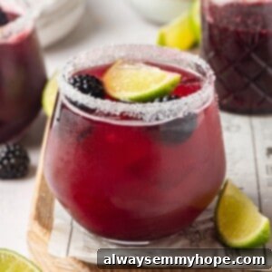 Refreshing Blackberry Margarita 2 Blackberry margarita in glass with salted rim and fresh berries and lime