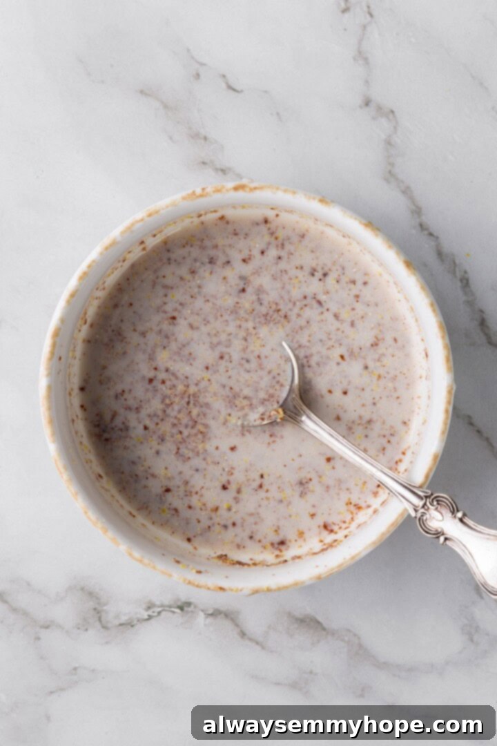 Overhead view of flax egg mixture in bowl with spoon