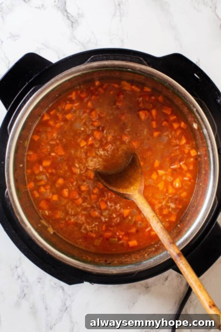 Instant Pot Mexican Rice is a total game-changer! It turns out perfectly cooked and fluffy every time. This easy recipe will be your go-to! Overhead view of liquid and rice added to Instant Pot for Mexican rice