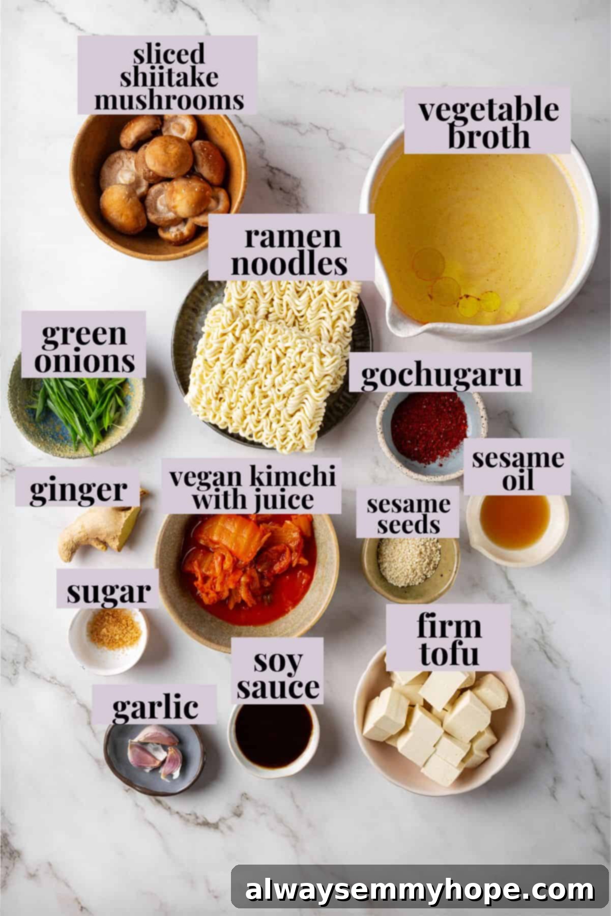 This spicy Kimchi Ramen is ridiculously easy, and the combination of tofu, kimchi, and shiitakes makes it a satisfying, flavour-packed meal! Overhead view of fresh ingredients for kimchi ramen, including chopped kimchi, sliced shiitake mushrooms, fresh ginger, garlic, green onions, and firm tofu.