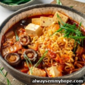 Spicy Kimchi Tofu Ramen 2 Close-up of a steaming bowl of Kimchi Ramen, garnished with fresh green onions and sesame seeds, showcasing the rich broth, noodles, tofu, and mushrooms.