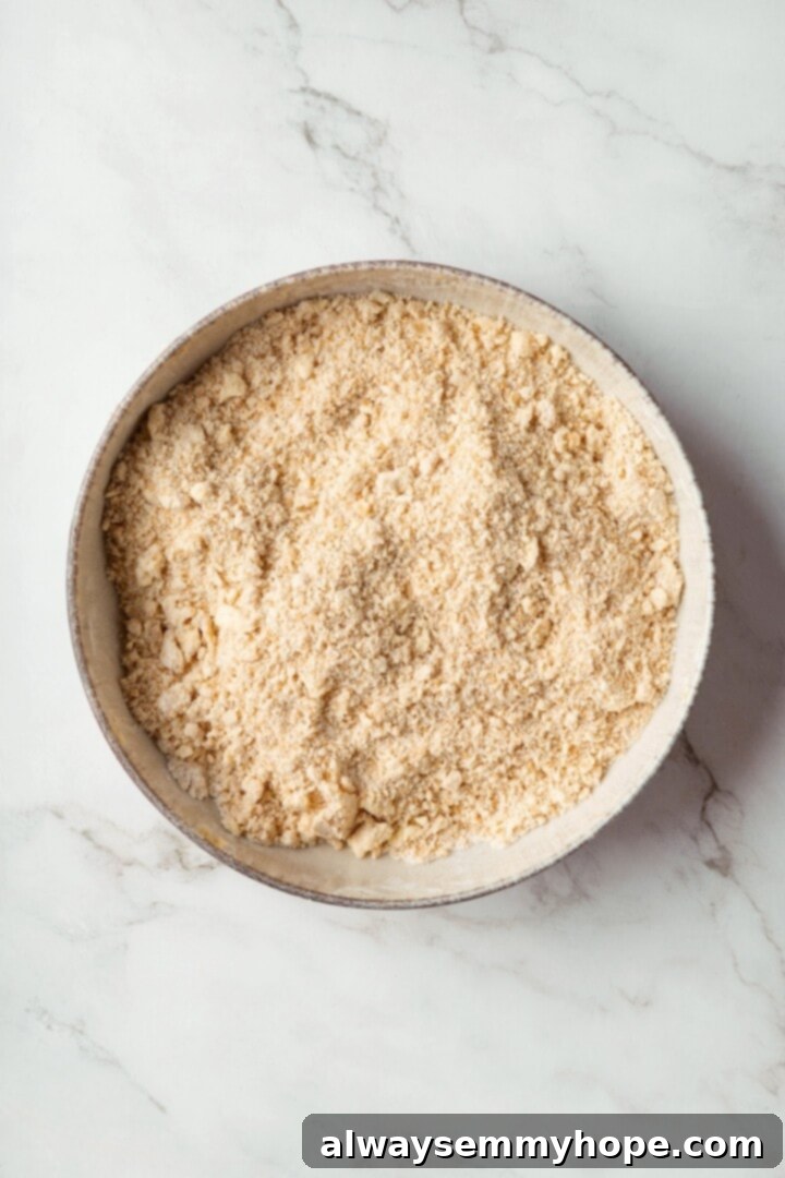 A little bit like coffee cake, this Blueberry Buckle is loaded with berries, then topped with brown sugar cinnamon streusel. So delicious! Overhead view of a bowl containing whisked dry ingredients for blueberry buckle: flour, baking powder, and salt.