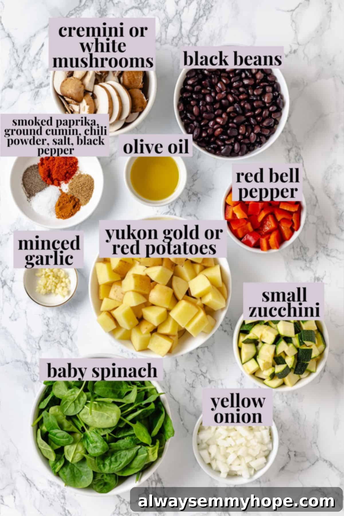 Overhead view of fresh breakfast hash ingredients laid out on a cutting board, including potatoes, onion, bell pepper, zucchini, mushrooms, and spices