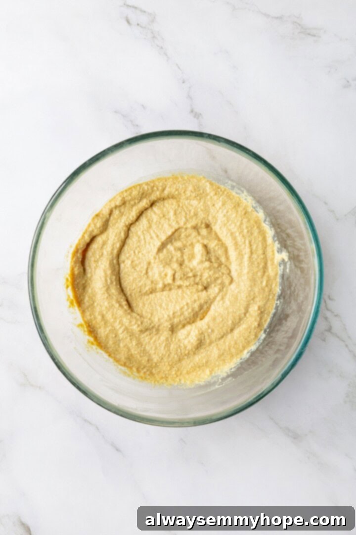 Overhead view of the smooth, creamy tofu 'egg' mixture in a glass bowl after blending