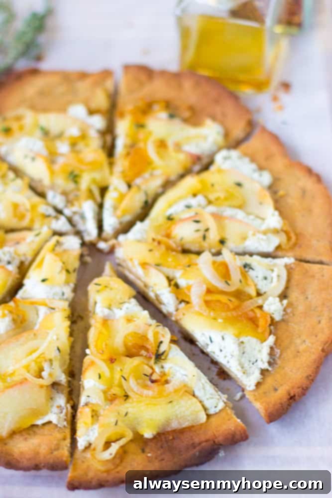 This Goat Cheese Pizza with Caramelized Onions and Apples is sprinkled with thyme, drizzled with honey and incredibly tasty! Individual slices of goat cheese pizza artfully arranged on a white table, showing the golden crust and bountiful toppings.