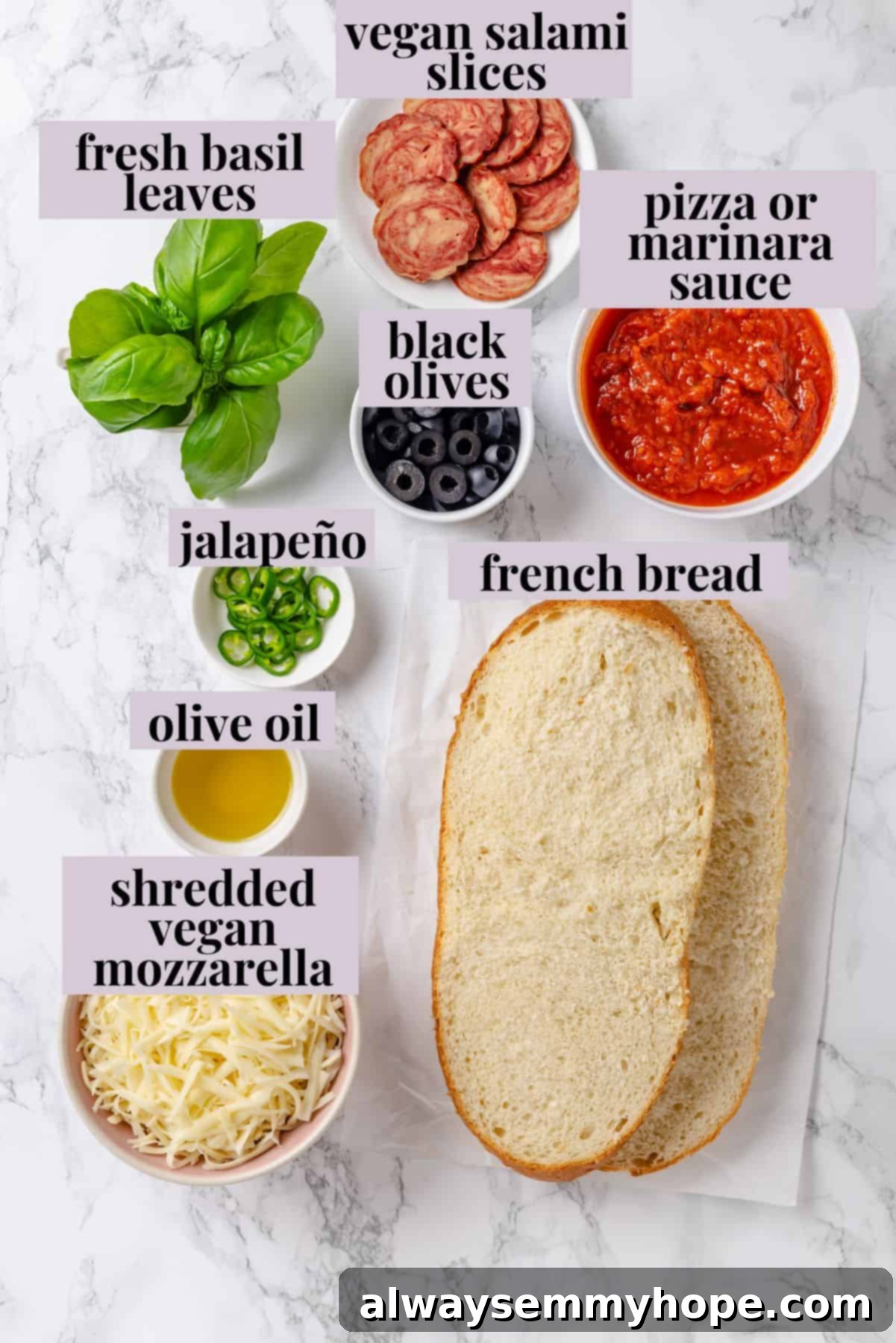 This vegan French Bread Pizza recipe is cheesy, easy and that thick, toasty base puts regular crust to shame. I’ve got two topping options! Overhead view of fresh ingredients for making French bread pizza, including bread, sauce, cheese, and toppings
